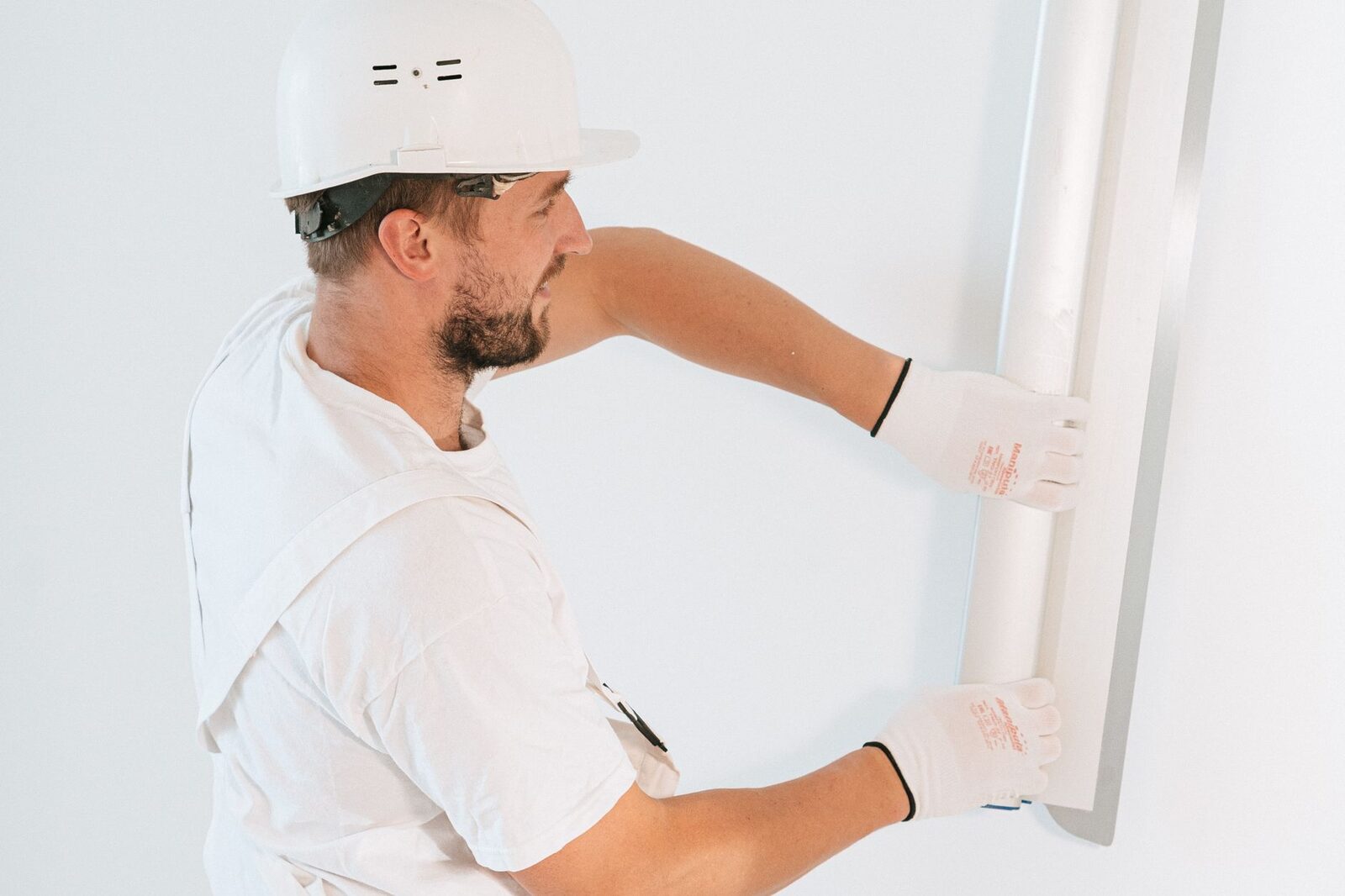 Technician installing drywall in a commercial interior